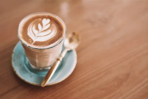 Latte art in a glass cup on a café table